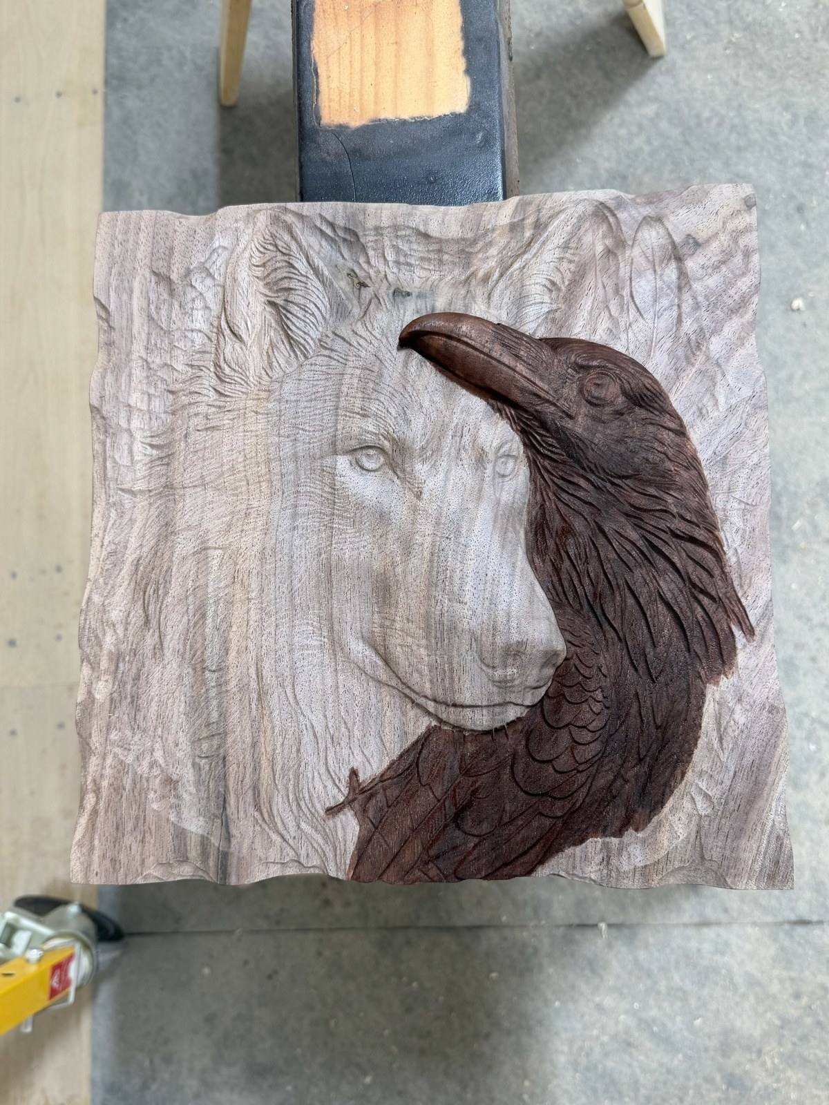 The bare walnut carving with only the raven tinted dark with dyed denatured alcohol, the wolf still natural