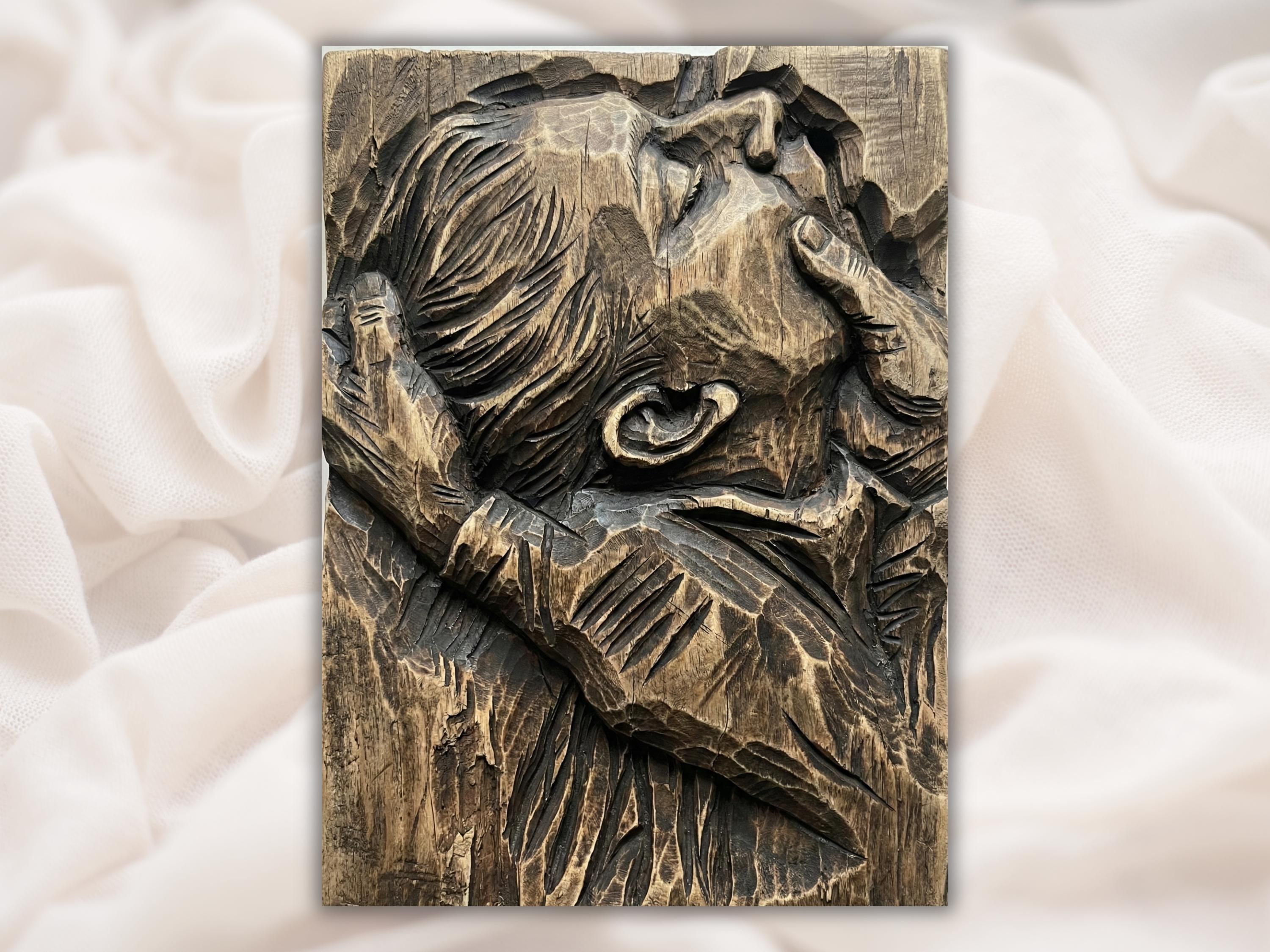 Carved wood bas-relief of an abstract couple kissing with flowing hair and deep chisel texture