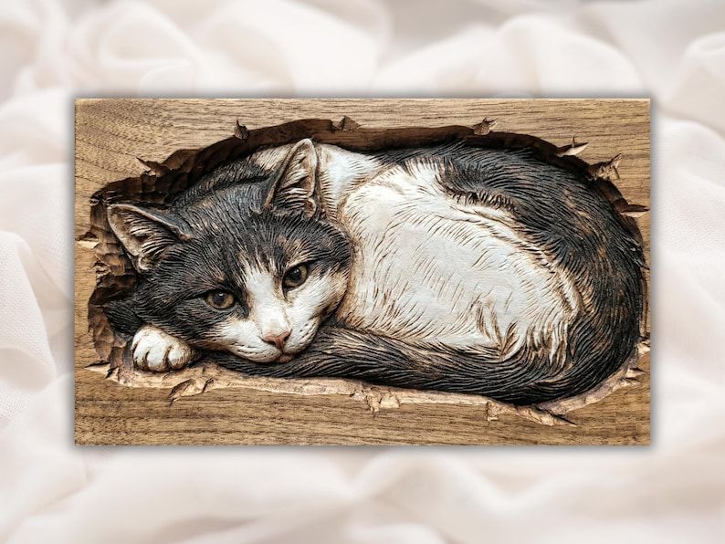 Bas-relief wood carving of a curled resting cat with open eyes, dark back and white belly, flowing fur
