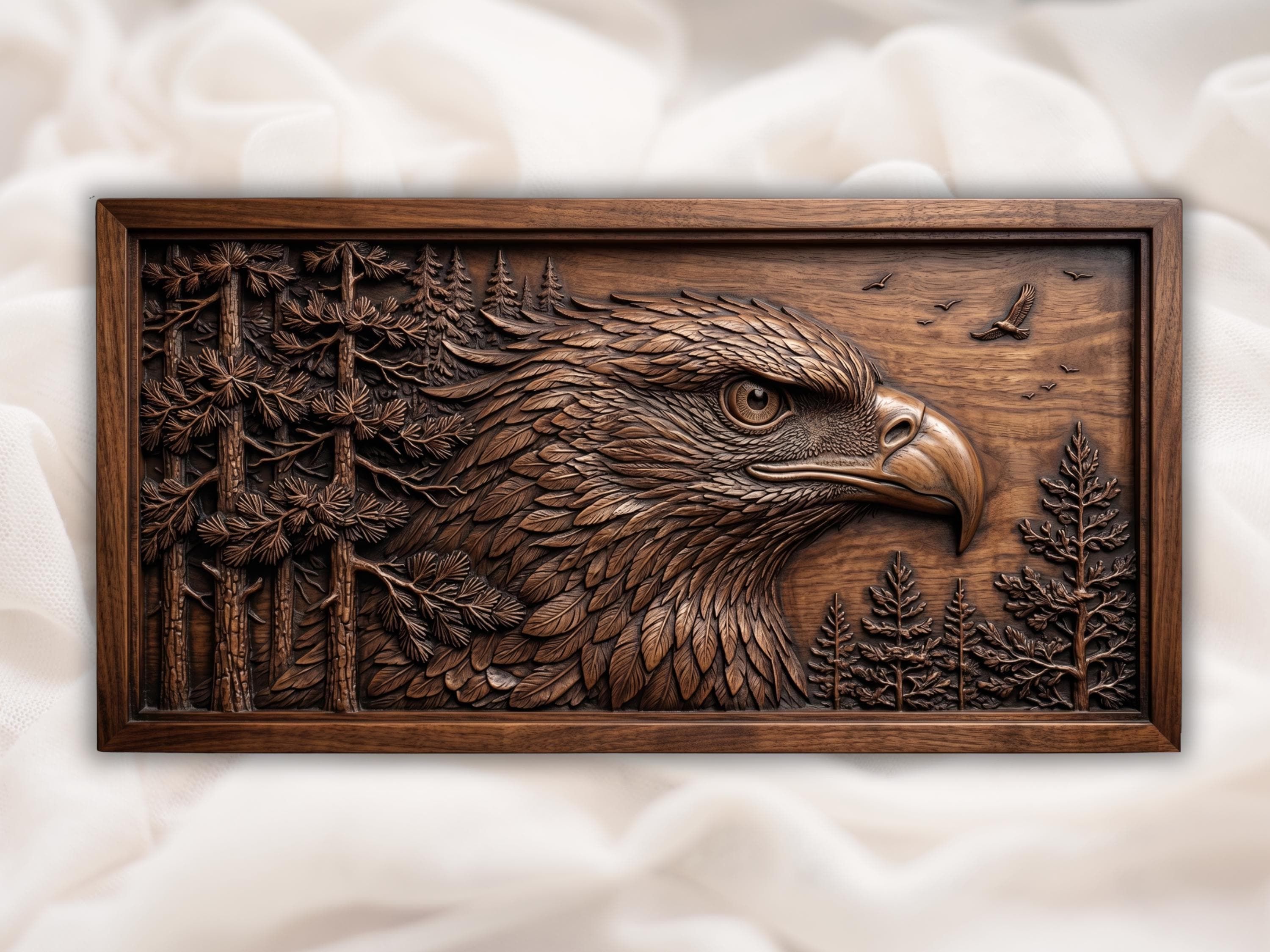 Carved wood bas-relief of a bald eagle head in profile with layered feathers and pine trees, in a framed panel