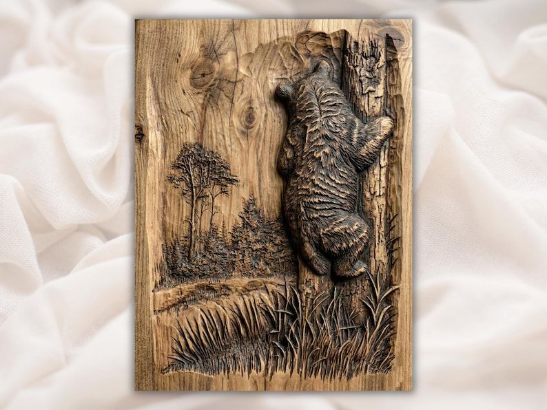 Carved wood relief of a black bear climbing a tree trunk with pine forest and grass behind it.