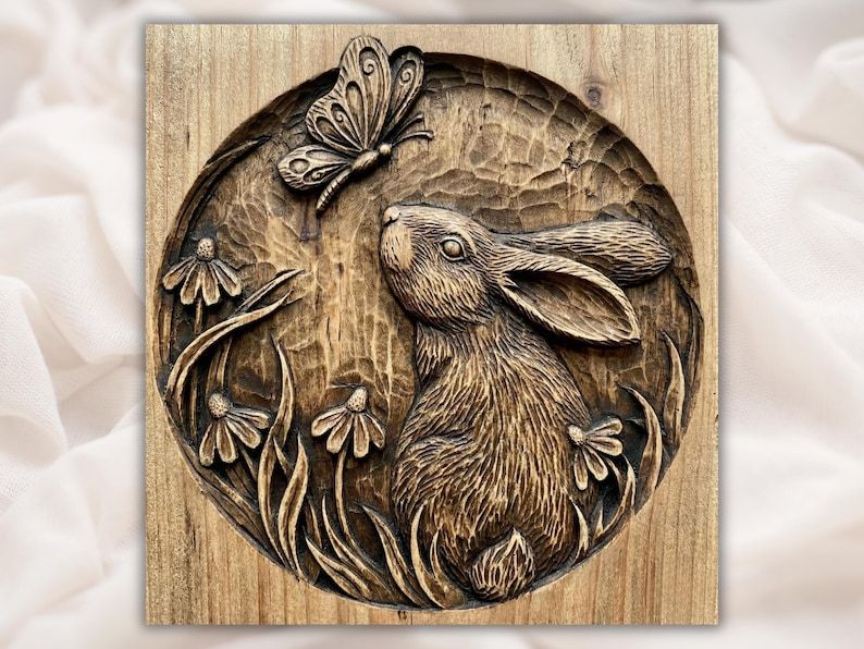 Round bas-relief wood carving of a rabbit looking up at a butterfly among wildflowers and grass.