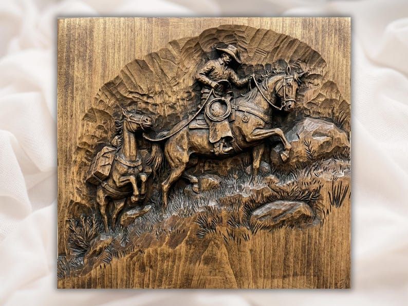 Carved wood relief of a cowboy on horseback leading a packhorse down a rocky slope with grass and stone