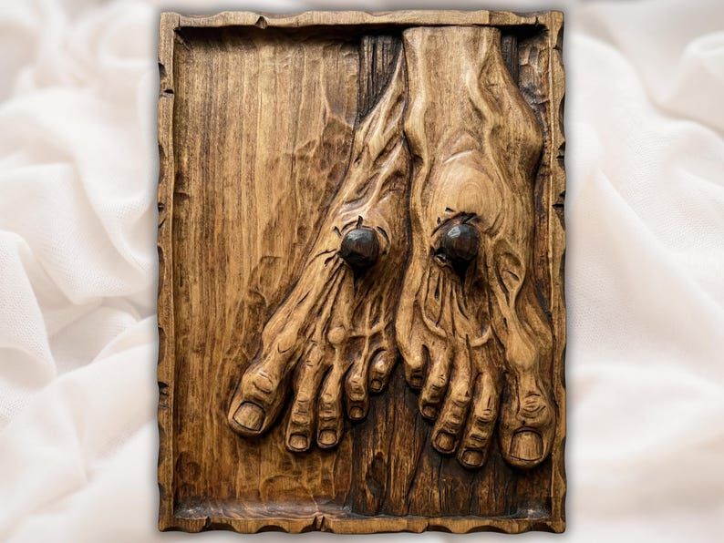 Carved wood bas-relief of the nail-pierced feet of Christ crossed on a recessed panel