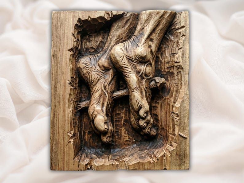 Carved bas-relief of the pierced feet of Christ crossed and held by a nail in torn wood