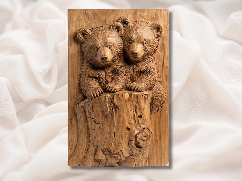 Bas-relief wood carving of two bear cubs leaning over a cracked tree stump