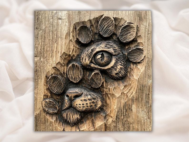 Carved wood panel of a paw print with a hidden cat face, one eye and a nose, set in rustic grain