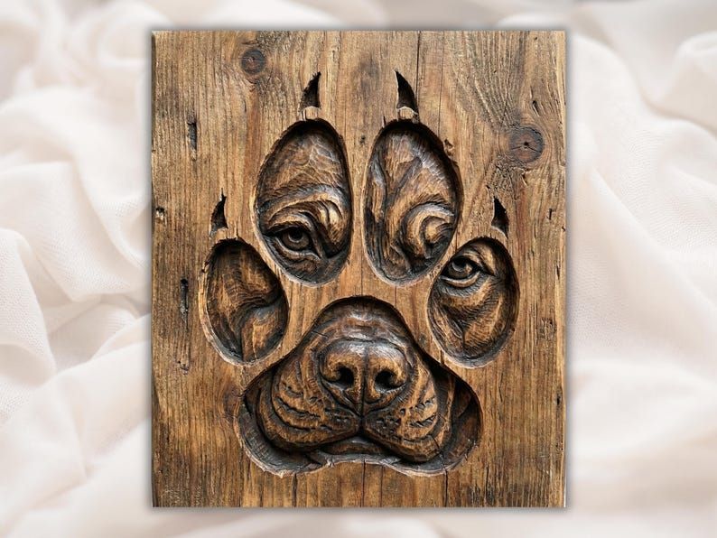 Carved wood bas-relief of a dog paw print with a hidden puppy face, eyes and nose, in the pads