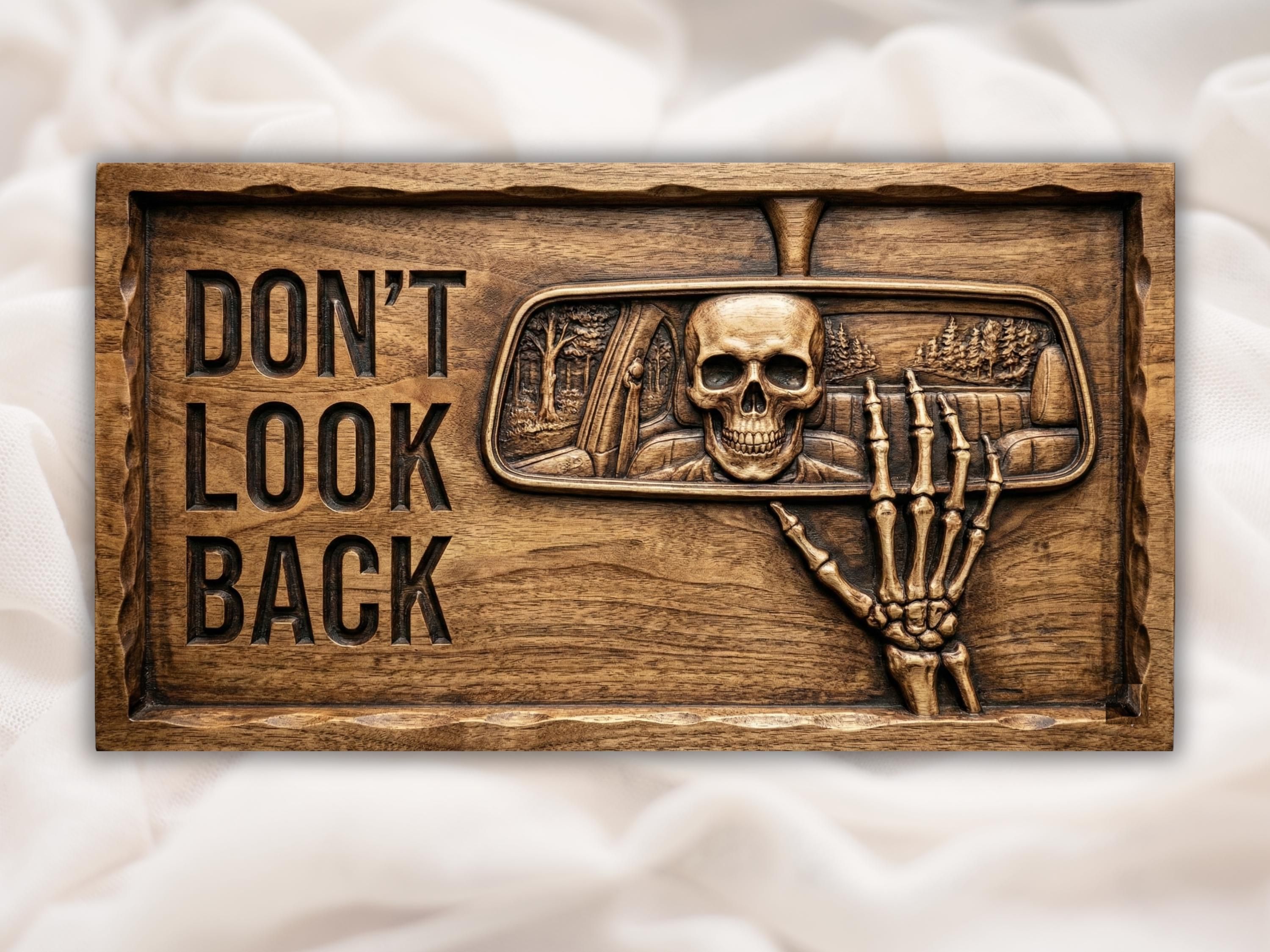 Bas-relief wood carving of a skull in a rearview mirror with a dark forest and a bony hand reaching up.