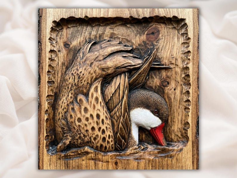 Bas-relief carving of a pintail duck preening with red bill and white throat, set in a rustic recessed wood panel.