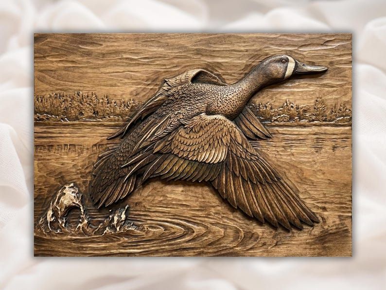 Carved wood bas-relief of a blue-winged teal duck lifting off water with ripples and a marsh background