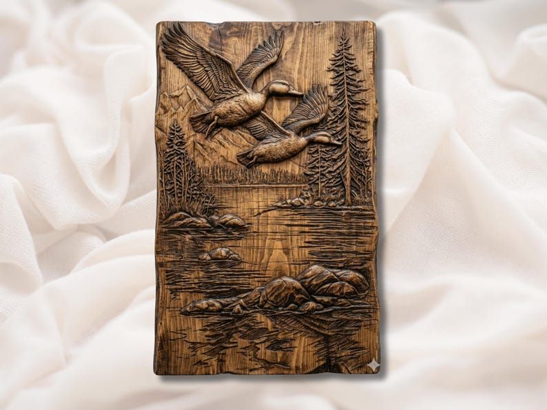 Carved wood bas-relief of two mallard ducks flying over a mountain lake with pine trees and rocks
