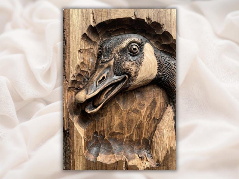 Bas-relief carving of a Canada goose head with open beak bursting through a wood panel