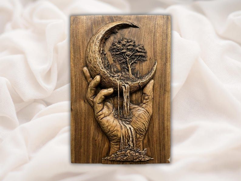 Wood relief carving of a hand holding a crescent moon with a tree inside and a waterfall flowing into stones