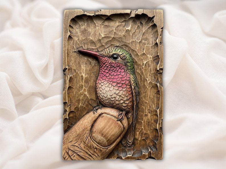 Carved wood bas-relief of a pink-throated hummingbird perched on a person's fingertip in a recessed panel.