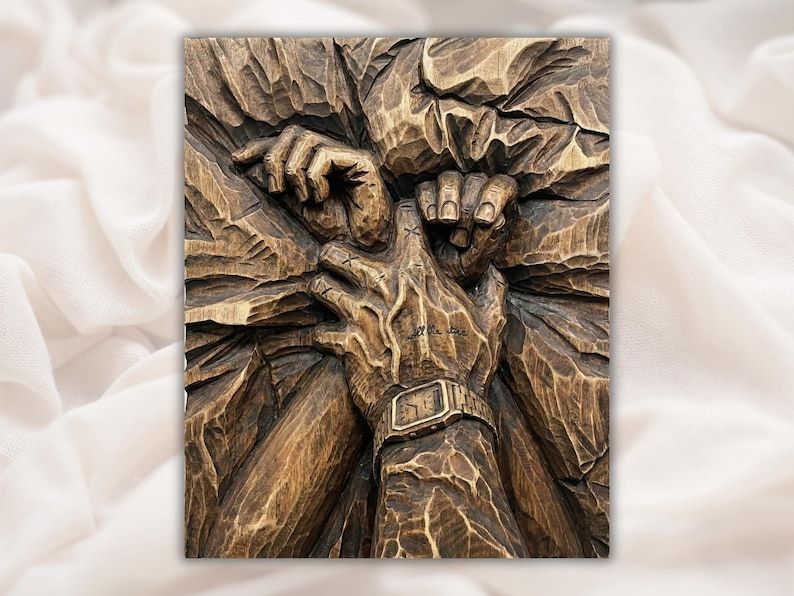 Wood relief carving of two hands tightly clasped together, one wrist wearing a watch, on a textured background
