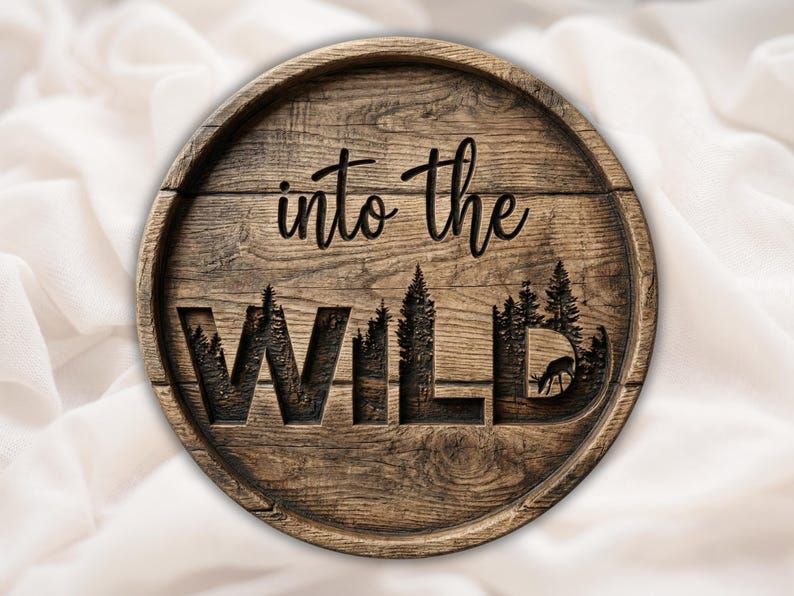 Round wood sign carved with script reading into the wild over pine trees and a deer inside bold WILD letters