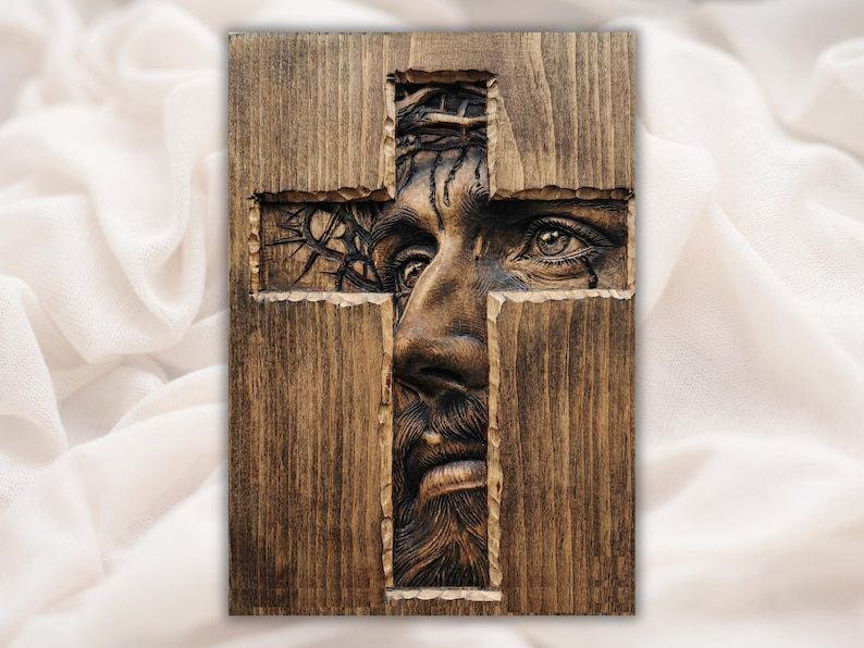 Bas-relief carving of the face of Jesus with crown of thorns revealed through a wood cross cutout