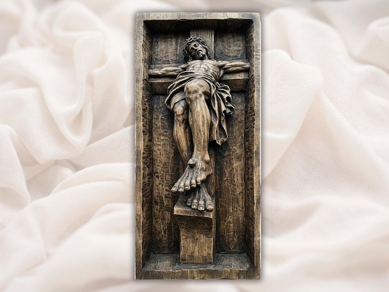 Bas-relief wood carving of the crucified Christ with crown of thorns on a cross inside a recessed frame panel.