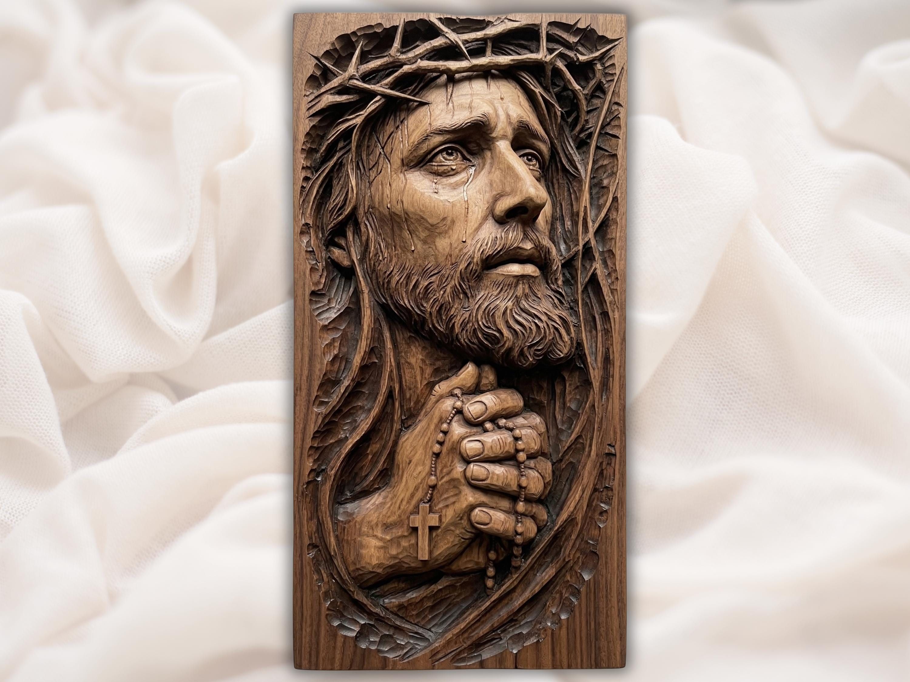 Carved wood relief of Jesus with crown of thorns and a tear, hands folded in prayer holding a rosary with cross.