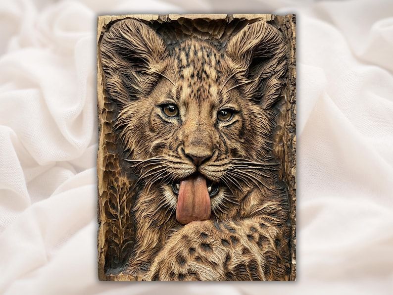 Bas-relief wood carving of a lion cub portrait with detailed fur and its tongue sticking out