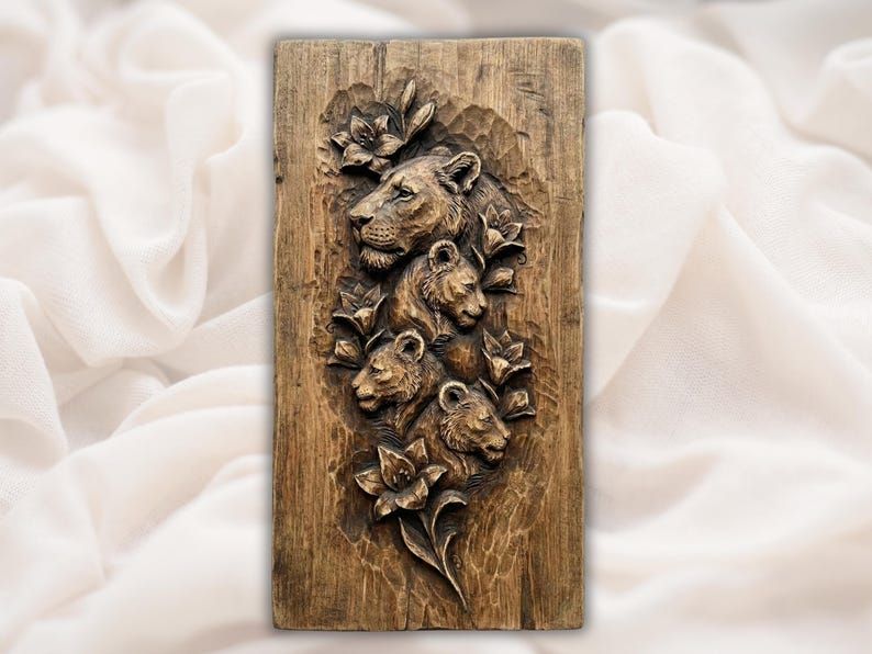 Carved wood bas-relief of a lioness and three cubs surrounded by lilies on a vertical panel