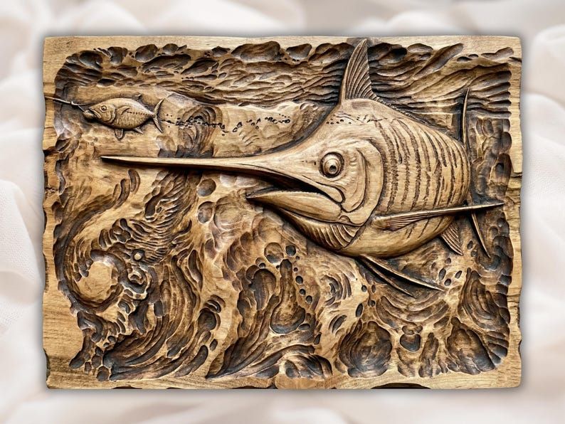 Carved wood bas-relief of a marlin leaping through ocean waves with a small fish behind it