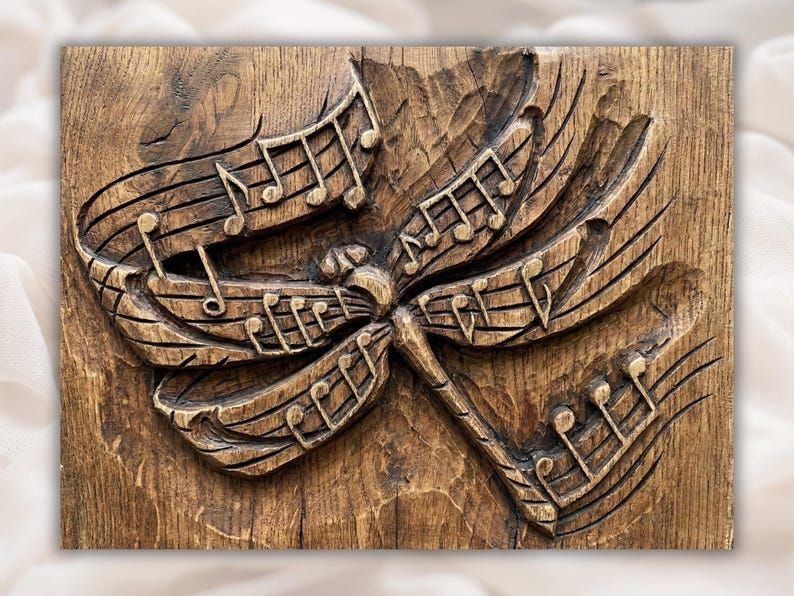 Carved wood bas-relief of a dragonfly with wings made of musical staff lines and notes