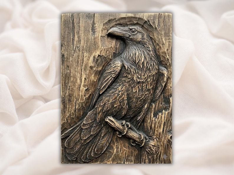 Bas-relief wood carving of a raven perched on a branch against a cracked, weathered wood-grain background.