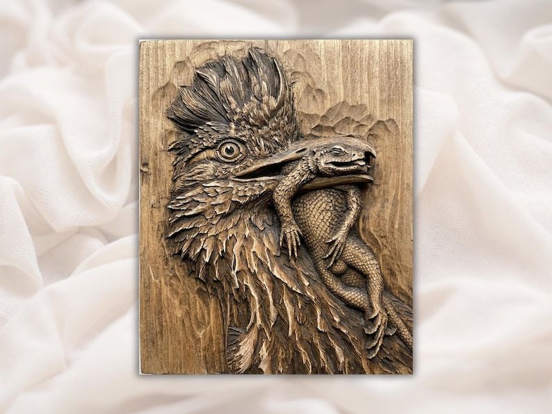 Carved wood bas-relief of a roadrunner with a lizard held in its beak, detailed feathers and scales