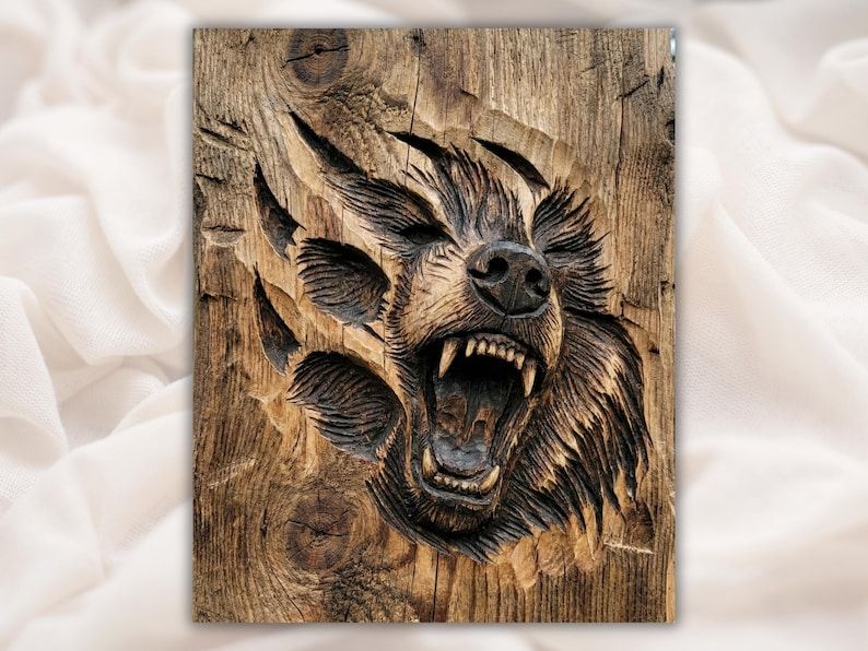 Carved bas-relief of a roaring bear head bursting through three torn claw marks in wood grain