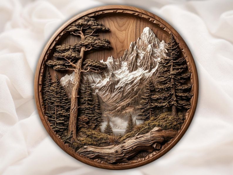 Round bas-relief carving of snowcapped mountains, pine forest, a lake, and a fallen log in the foreground.