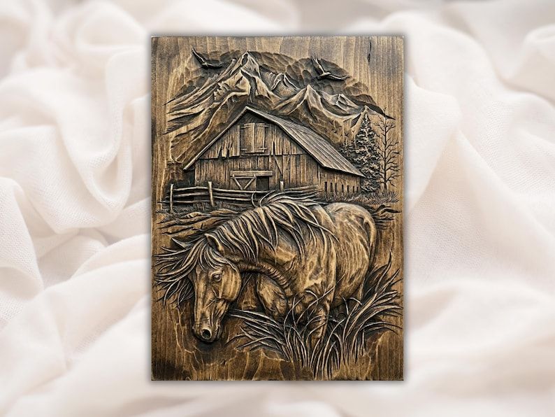 Bas-relief wood carving of a grazing horse with a rustic barn and mountain peaks behind it