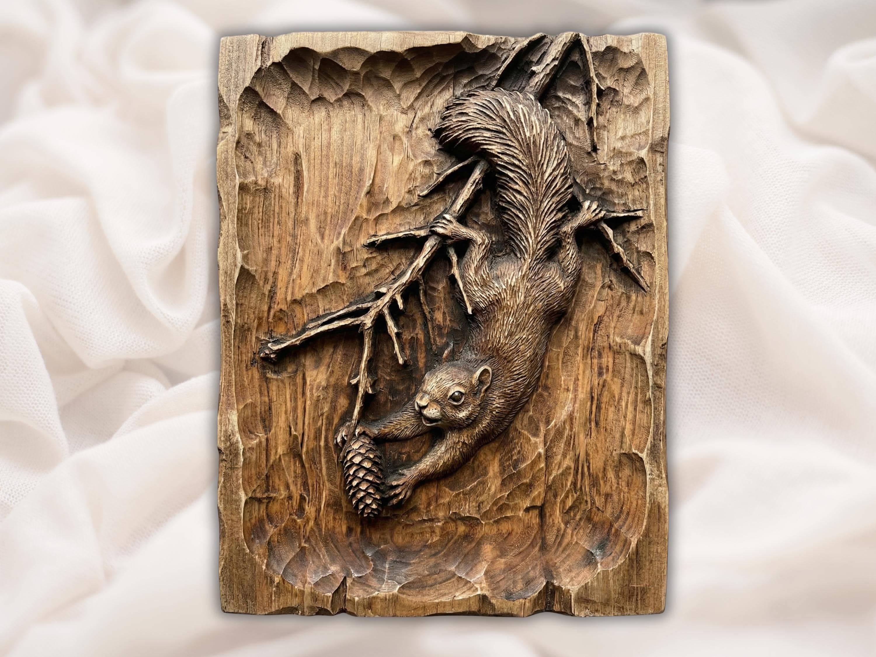 Bas-relief wood carving of a squirrel on a branch holding a pinecone with a large bushy tail