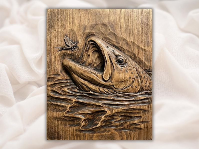 Carved wood bas-relief of a trout with open mouth rising to strike a mayfly above rippling water