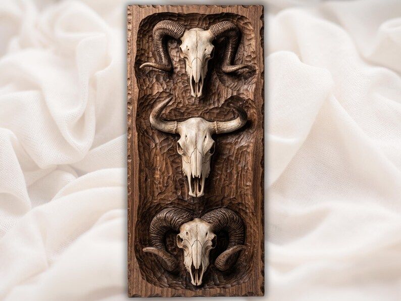 Carved wood relief of three animal skulls stacked vertically, two ram skulls framing a central horned bull skull
